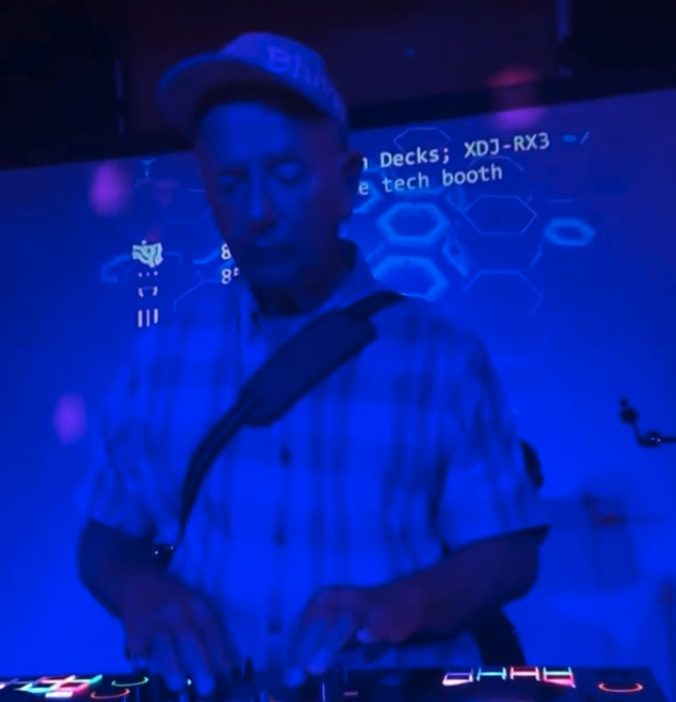 Vinny DJing at NextDoor Club in Honolulu, lit by deep blue stage lights.