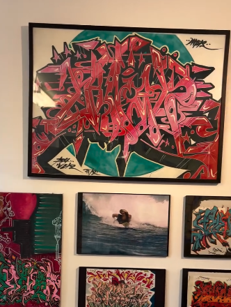 Wall-mounted collection of graffiti-inspired paintings, ocean scenes, and abstract forms