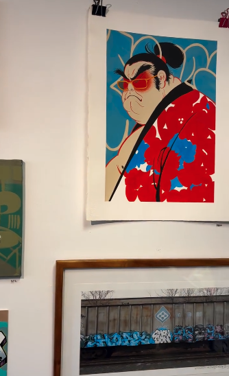 Portrait painting of a man in red, displayed above framed street art